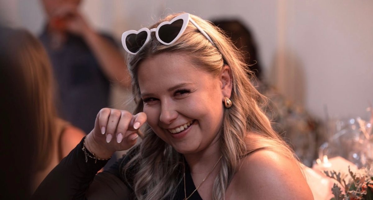 Justine souriante, lunettes cœur sur la tête