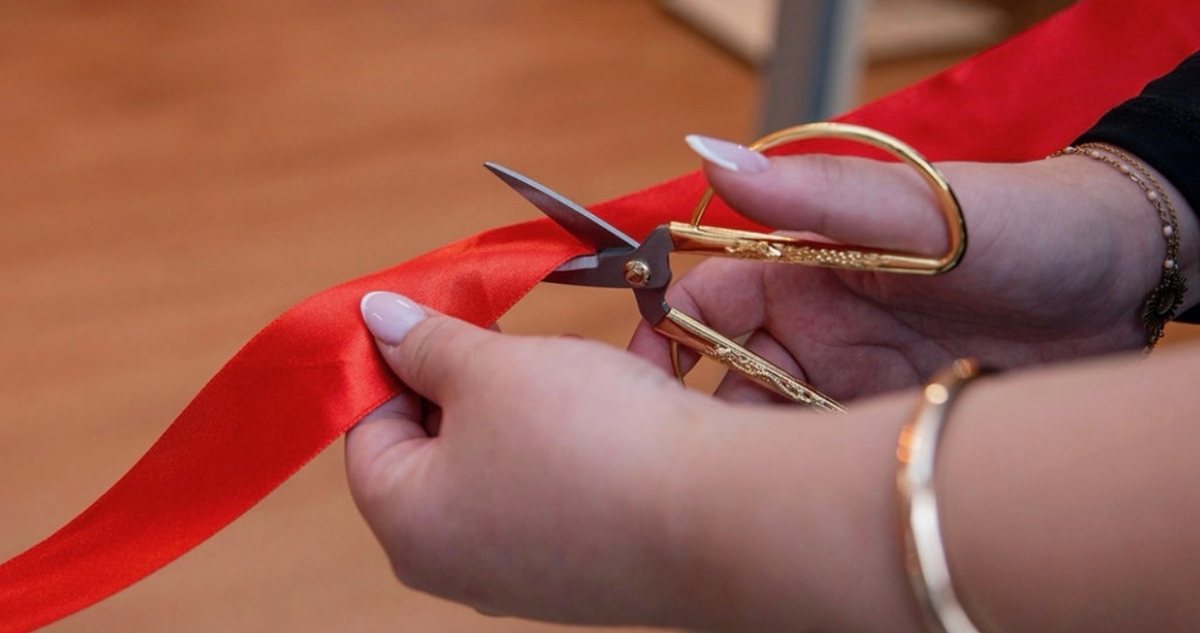 Le ruban rouge coupé avec des ciseaux dorés