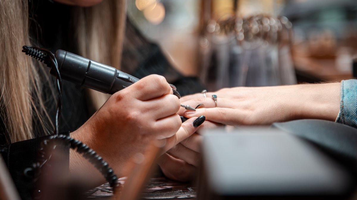 Préparation de l'ongle à la ponceuse pendant une manucure chez Studio by Ju